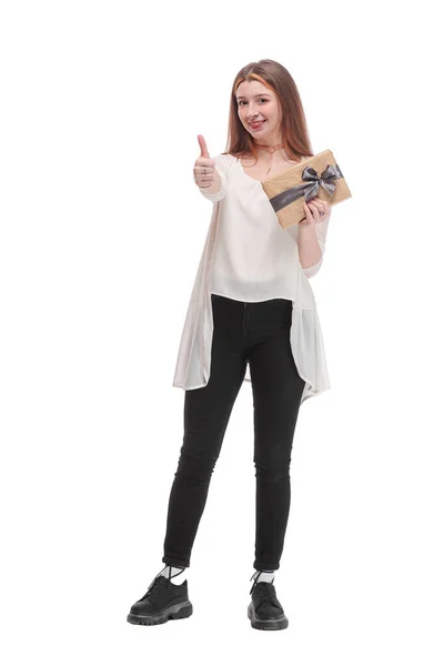 Neşeli, esmer bir kız elinde hediye kutusuyla baş parmağıyla beyaz arka plan stüdyo resminde yalnız poz veriyor. — Stok fotoğraf