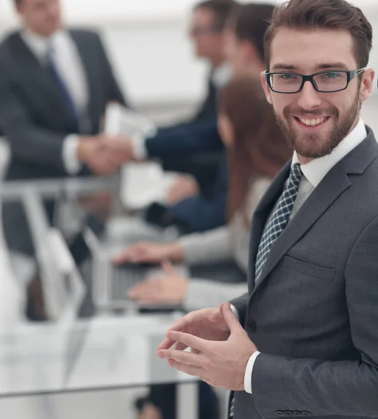 Lächelnder Geschäftsmann vor dem Hintergrund seines Amtes — Stockfoto