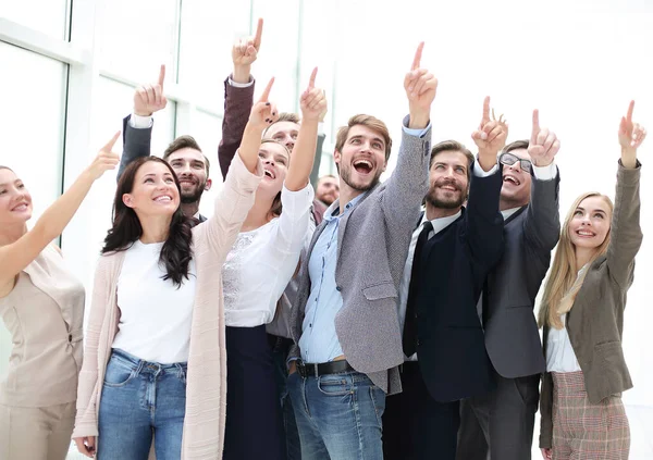 Group of happy young business people pointing upwards — Stock Photo, Image