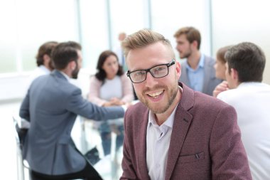 Kapat. Başarılı genç adam müzakere masasının yanında oturuyor.