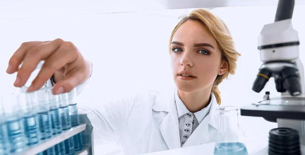 Mujer joven analizando muestras en un laboratorio — Foto de Stock