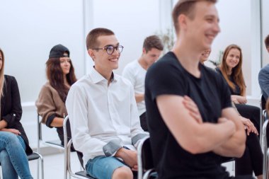 Yan görünüş. Gündelik gençlik grubu konferans odasında oturuyor.