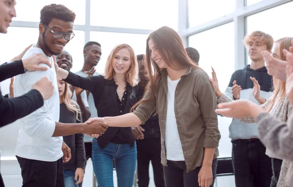 Glückliche junge Leute gratulieren ihrem Kollegen — Stockfoto