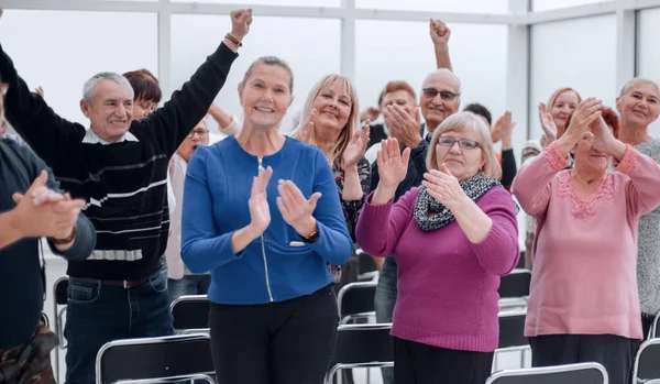 Pubblico di adulti ascoltano il discorso del docente applaudire e sorridere — Foto Stock