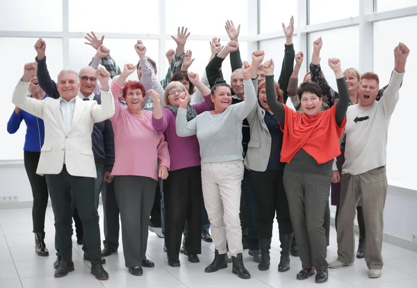 Az emberek boldog csoportja felemeli a kezét a győzelem öröméért. — Stock Fotó
