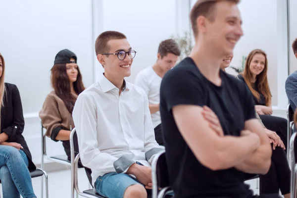 Seitenansicht. Lässige Gruppe junger Leute sitzt im Konferenzraum — Stockfoto