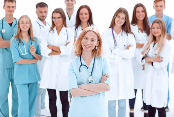 Mladá zdravotnice stojící před svými kolegy — Stock fotografie