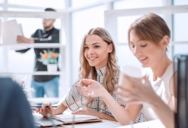 İş adamları ofiste duran bir şeyi tartışıyor.