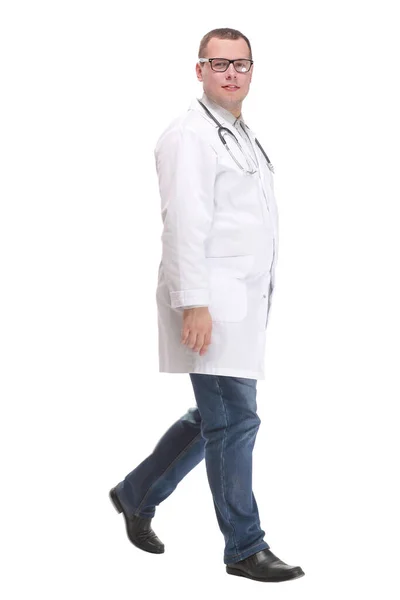 Médico masculino caminhando isolado sobre um fundo branco olhando para a vista da câmera — Fotografia de Stock