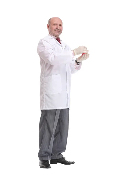 Зрілий вчений з сірим волоссям і бородою в білому пальто стоїть з склянкою в руці і тримає медичний тест — стокове фото