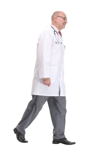 Oude mannelijke arts loopt weg en kijk weg geïsoleerd op wit — Stockfoto