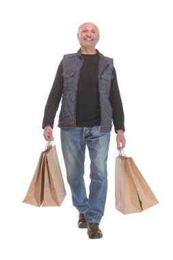 Gülümseyen olgun bir adam alışveriş torbaları tutuyor.