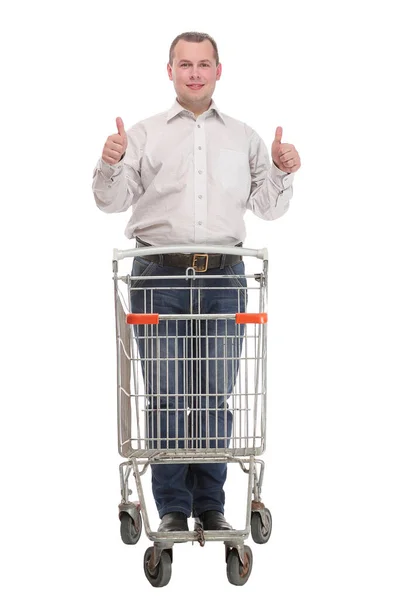 Homem bem vestido com um carrinho de compras vazio fazendo um gesto de polegar para cima — Fotografia de Stock