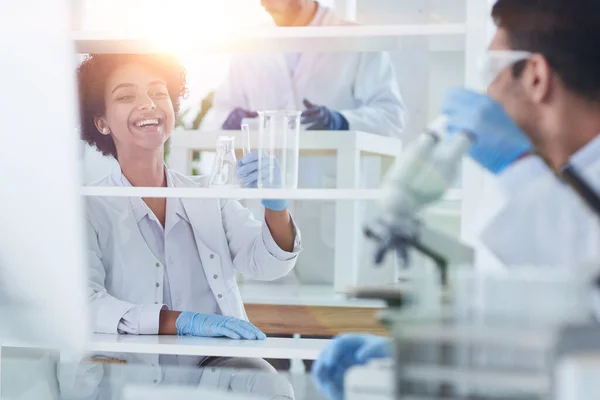 Des scientifiques souriants regardant des bras de caméra croisés en laboratoire — Photo