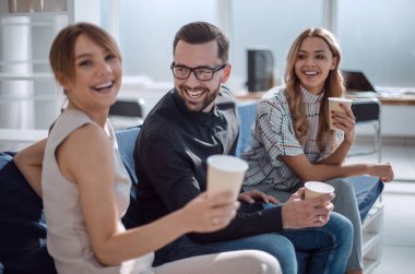 İş yerinin lobisinde oturan iş ekibi.