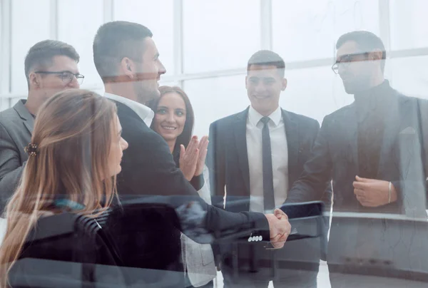Business team standing in front of a glass wall. — Stock Photo, Image