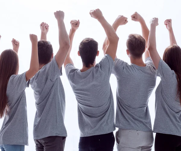 Visão traseira. grupo de jovens felizes com as mãos para cima Imagem De Stock