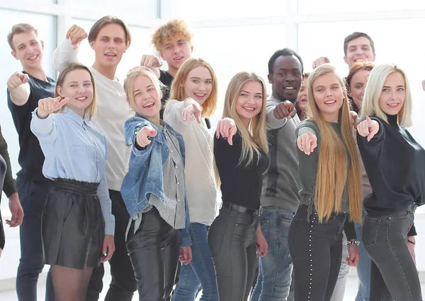 Grande grupo de jovens felizes aponta à frente. — Fotografia de Stock