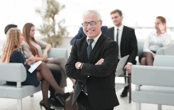 Улыбающийся старший бизнесмен на фоне деловой команды — стоковое фото