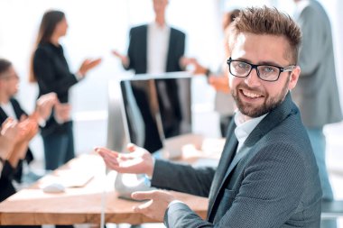 Dikiz aynası. Gülümseyen iş adamı ofis masasında oturuyor..