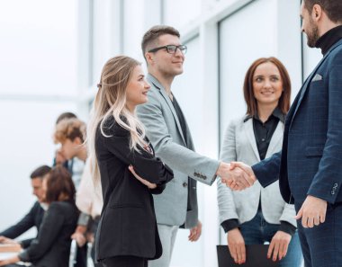 İş arkadaşları el sıkışarak birbirlerini selamlıyorlar.