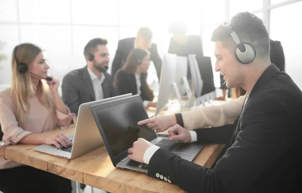 Jong call center medewerker zit aan zijn bureau — Stockfoto