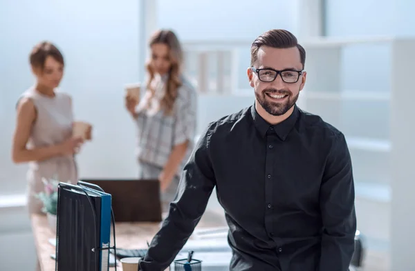 Glimlachende jonge zakenman in functie — Stockfoto