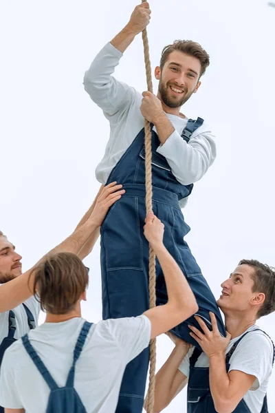 グループ労働者は仲間が登るのを助け — ストック写真