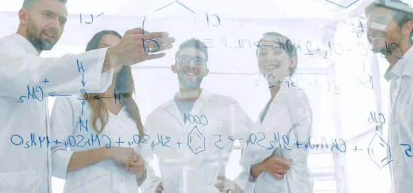 Группа ученых-лаборантов, обсуждающих свои исследования в — стоковое фото