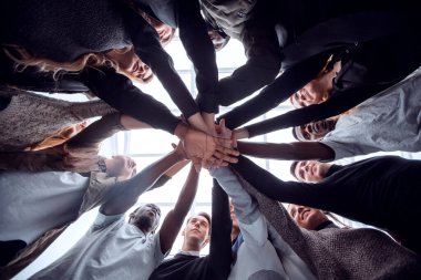 Alt manzara. Bir grup mutlu genç insan ellerinden bir kule yapıyorlar. .