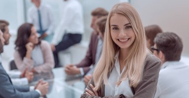 Kapat. Gülümseyen genç çalışan ofiste duruyor.