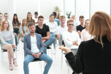 Bir konferans odasında rapor okuyan bir konuşmacının kırpılmış görüntüsü