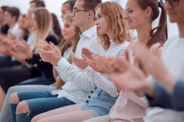 Kapat. Genç insanlar arka arkaya alkışlıyorlar..