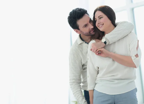 Background image of the embracing couple standing in a new apartment — Stock Photo, Image