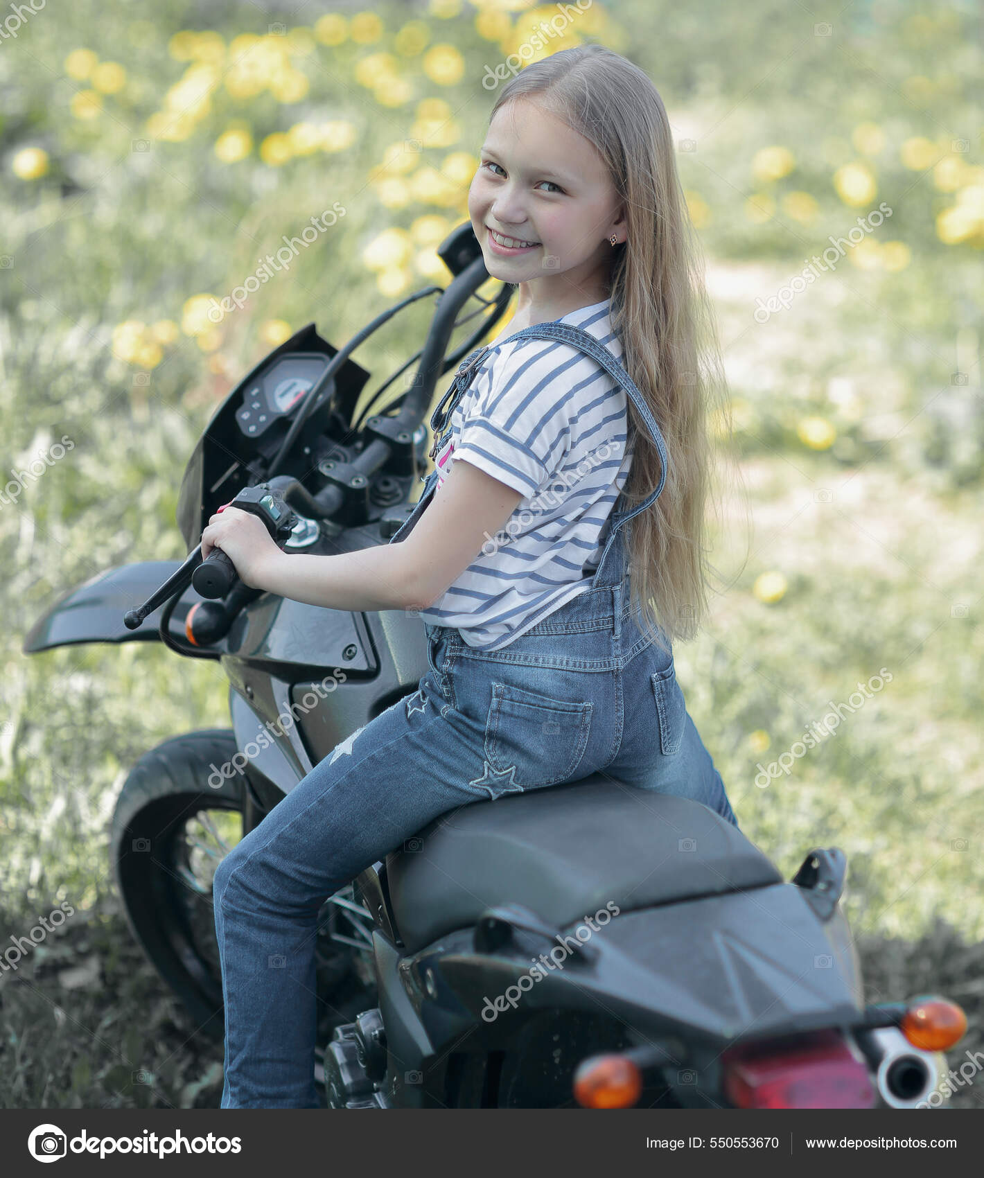 Little biker girl riding her motorcycle Stock Photo depositedhar 550553670
