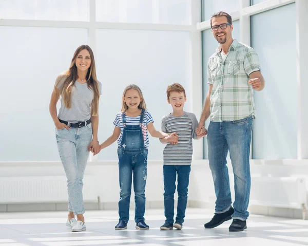 Счастливые родители с детьми, стоящими в новой квартире — стоковое фото