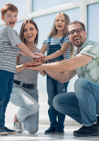 Pais felizes e seus filhos construíram uma torre fora de suas mãos — Fotografia de Stock