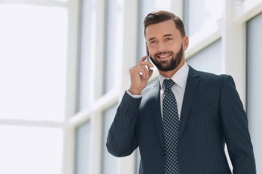 Kapat. Gülümseyen iş adamı telefonda konuşuyor.