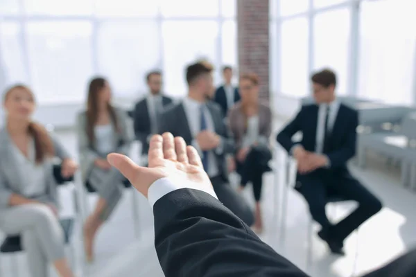 Visão traseira. Treinador de negócios gesticulando a mão na frente de um grupo de pessoas . — Fotografia de Stock