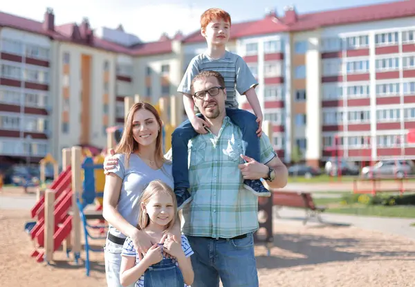 Młode Rodziny Stojąc Zagrodzie Nowej Koncepcji Mieszkalnych Building Rodzicielstwa — Zdjęcie stockowe