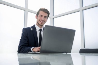 Başarılı bir iş adamı, fotokopi alanı olan bir dizüstü bilgisayar üzerinde çalışıyor.