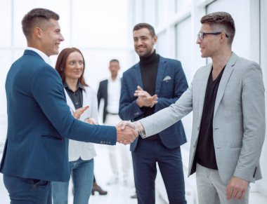 İş ortakları ofiste el sıkışıyor. İşbirliği kavramı