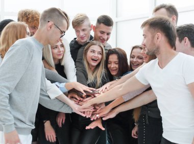 Kapat. Geniş bir grup genç ellerini birleştiriyor.