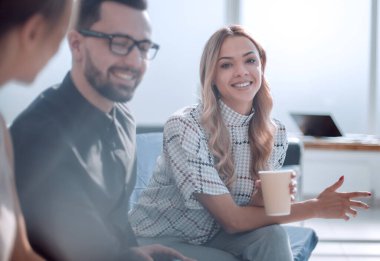 Ofis lobisinde kahve bardakları olan şirket çalışanları oturuyor. Takım çalışması kavramı
