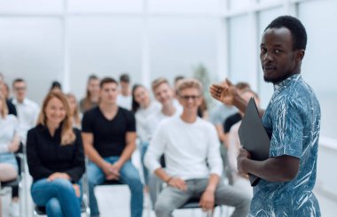 Üst Manzara. Bir grup genç yerde oturuyor ve kameraya bakıyor..