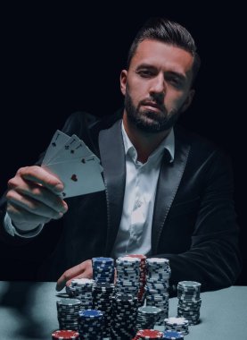 Tişörtlü, poker oyunu oynarken hes ise genç, kendine güvenen, gangster adam görünümünü.