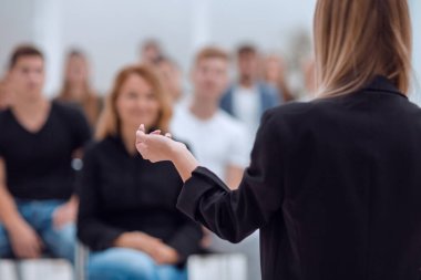 Dikiz aynası. Genç bir kadın bir grup genç için rapor hazırlıyor. iş ve eğitim