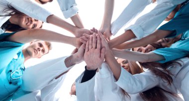 Alt manzara. Bir grup tıp arkadaşı ellerini birleştiriyor. Takım çalışması kavramı