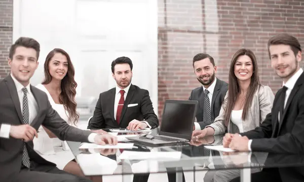 做出重要的决定 一组商务人士坐在办公室桌旁 免版税图库图片