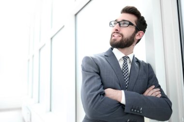 up.Portrait parlak bir ofiste ayakta emin işadamı kapatmak.